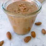 Homemade Almond Butter in a weck jar with almonds surrounding it.