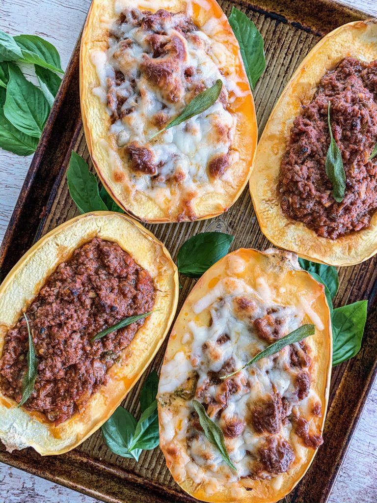 open faced spaghetti squashes stuffed with meat sauce and topped with cheese.