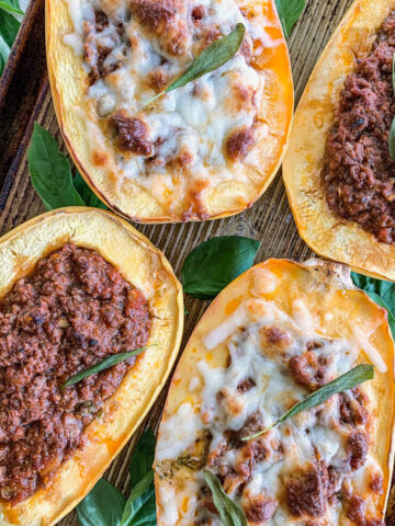 Stuffed Spaghetti Squash With Ground beef and two are topped with cheese on a baking sheet.
