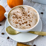 Pumpkin Spice Latte in a white mug with a gold spoon.