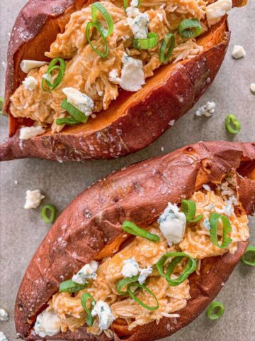 Slow Cooker Buffalo Chicken Stuffed Sweet Potatoes. Topped with blue cheese and green onions.