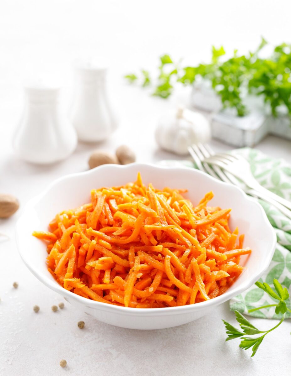 Raw carrot salad in a white bowl.