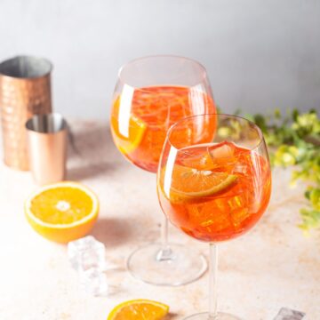 Two glasses of Aperol Soda with orange slices.