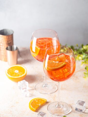 Two glasses of Aperol Soda with orange slices.