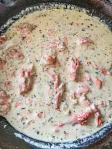 Cream sauce with cooked salmon mixed in a cast iron skillet.