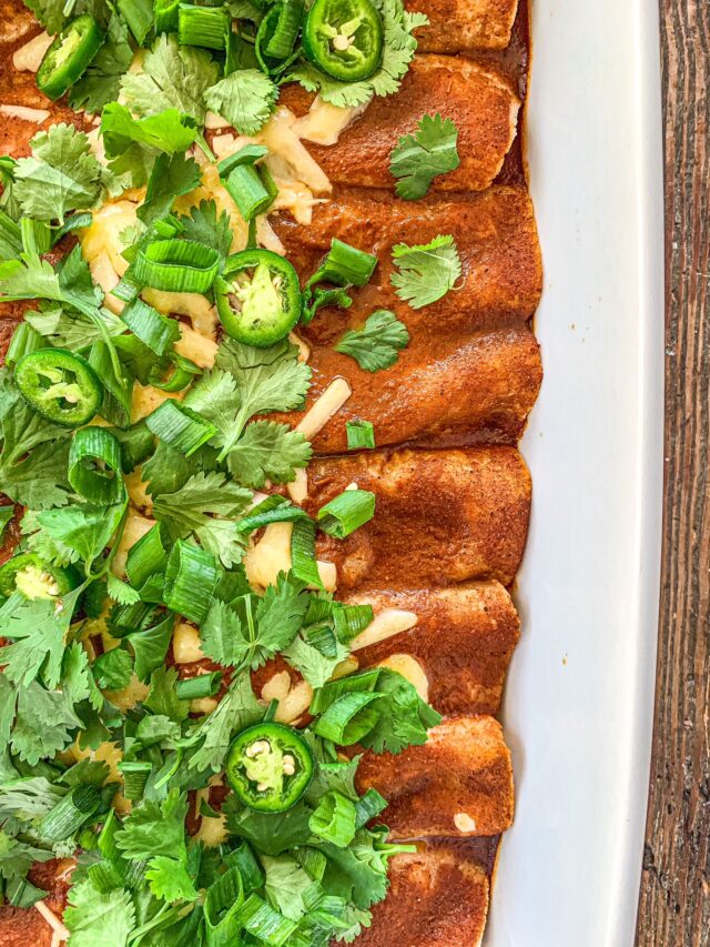 Gluten-Free Enchiladas topped with red sauce, cilantro, jalapeño and cheddar cheese.