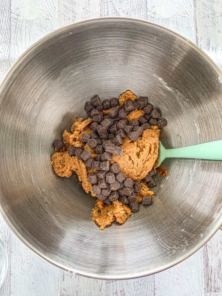 Gluten-Free Dairy-Free Cookie dough with chocolate chips in the base of a stand mixer.