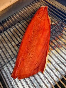 Salmon filet on the grill grates of a Traeger grill.
