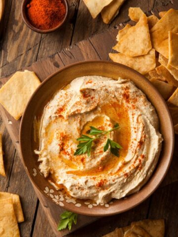 Hummus topped with fresh parsley and cayenne pepper.