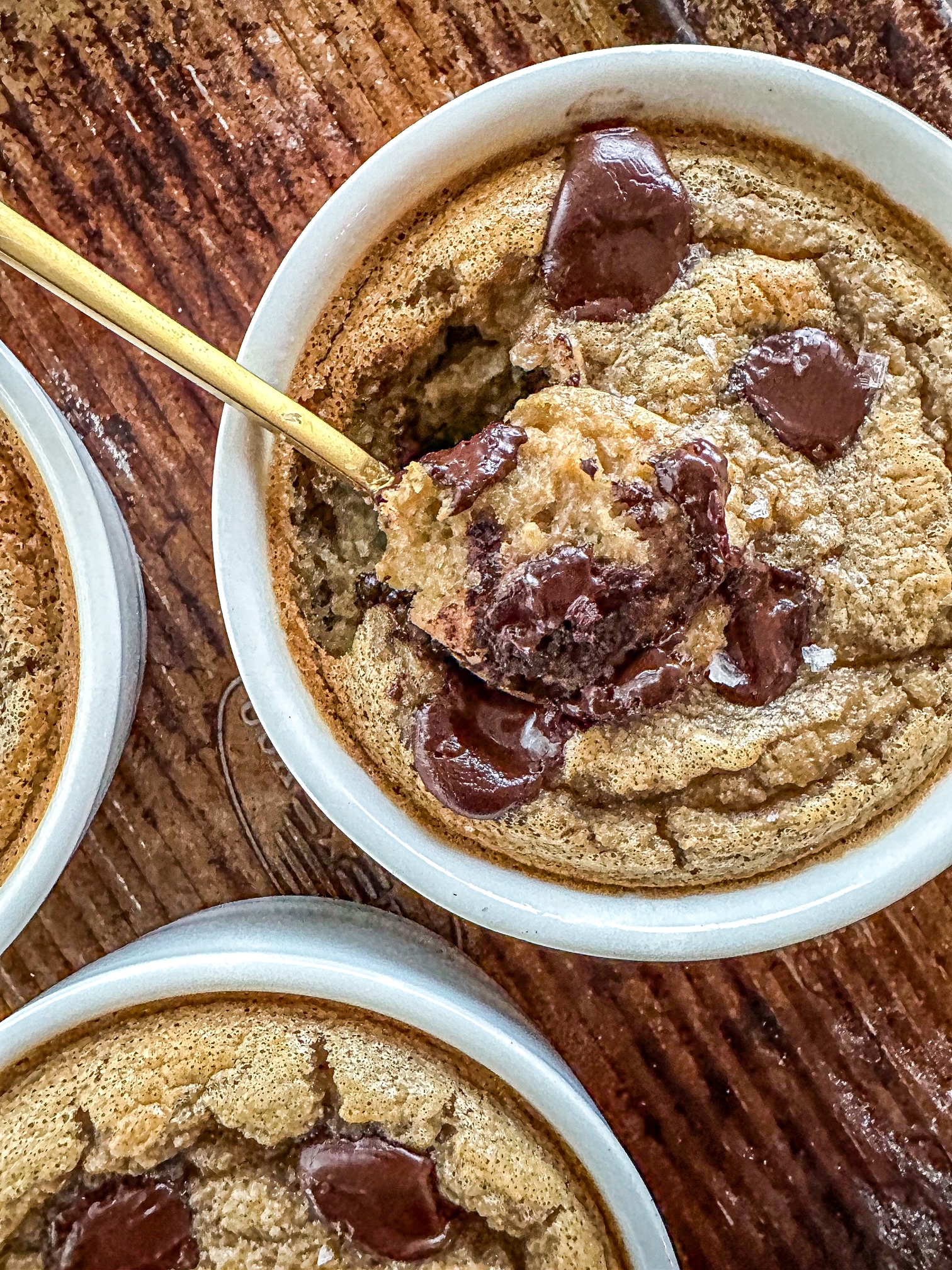 Cookie Dough Baked oats in a white ramekin with a gold spoon sticking out of it.