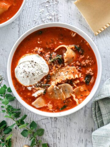 Lasagna Soup topped with whipped cottage cheese in a white bowl.