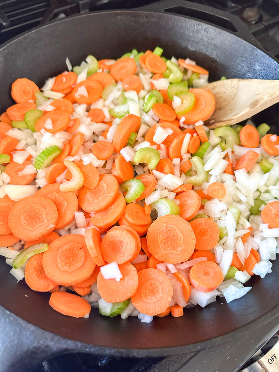 Onions, carrots and celery in a cast iron skillet.
