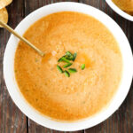 Cottage Cheese Queso in a white bowl with a gold spoon. Topped with jalapenos.