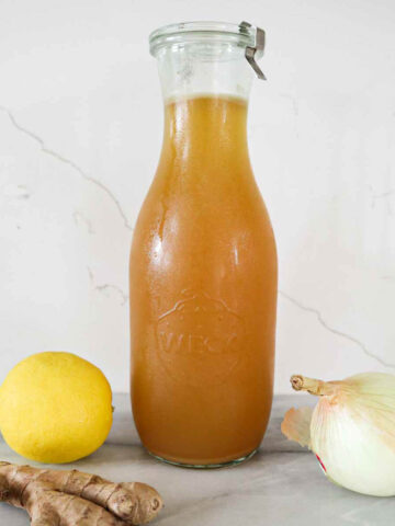 Rotisserie Chicken Bone Broth in a weck jar with lemon, onion and ginger.