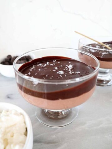 Chocolate cottage cheese mousse in a glass serving dish topped with a hard chocolate shell and sea salt.