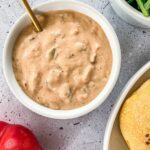 Smashburger sauce in a white bowl with a gold spoon sticking out of it.
