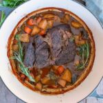 Dutch Oven Pot Roast with a sprig of rosemary.