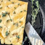 Feta cheese with hot honey and thyme in a cast iron skillet.