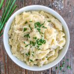 Truffle Mashed Potatoes in a white bowl topped with chives.