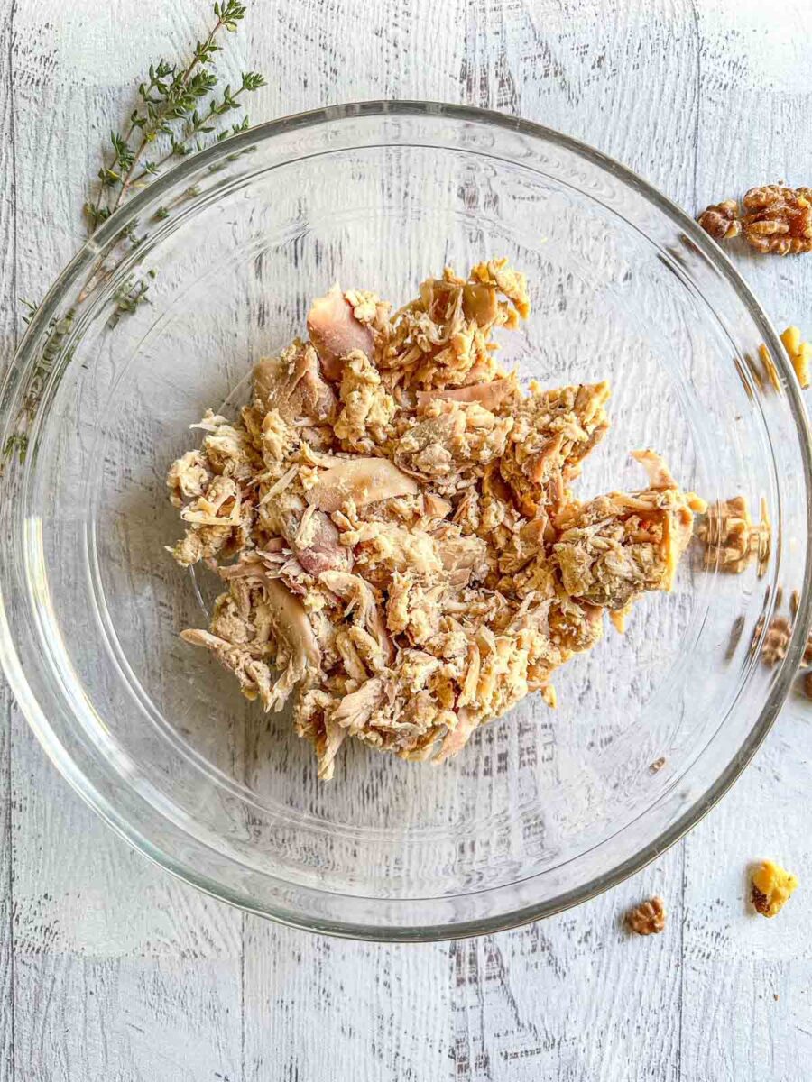 Shredded chicken in a glass bowl.