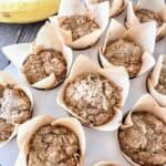 Banana Cottage Cheese Muffins in parchment liners in a muffin tin.