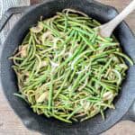 A cast iron skillet filled with smoked green beans.