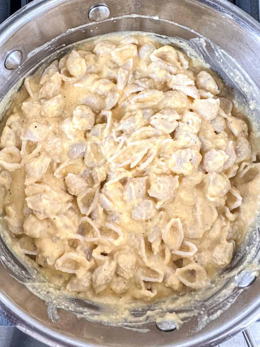 A stainless steel pan filled with creamy butternut squash feta pasta.