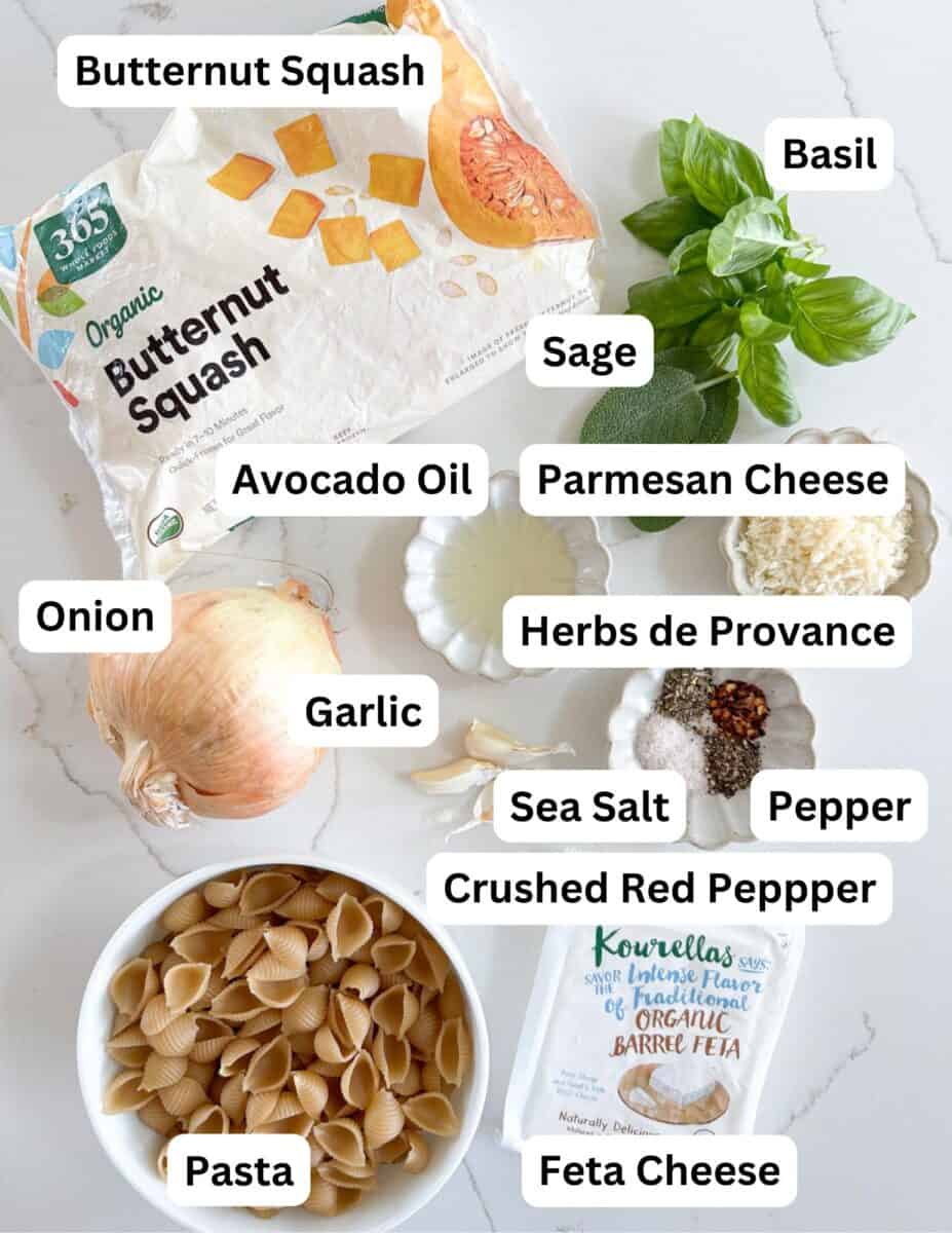 Labeled ingredients for a pasta dish, including butternut squash, onion, garlic, pasta shells, feta cheese, parmesan cheese, basil, sage, herbs de Provence, avocado oil, sea salt, pepper, and crushed red pepper.