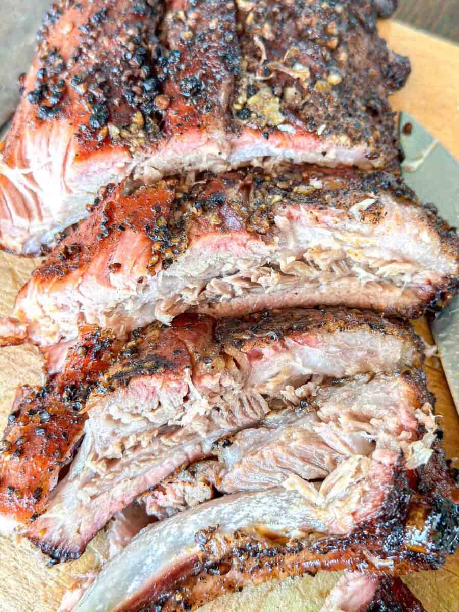 Traeger smoked ribs cut apart on a cutting board.