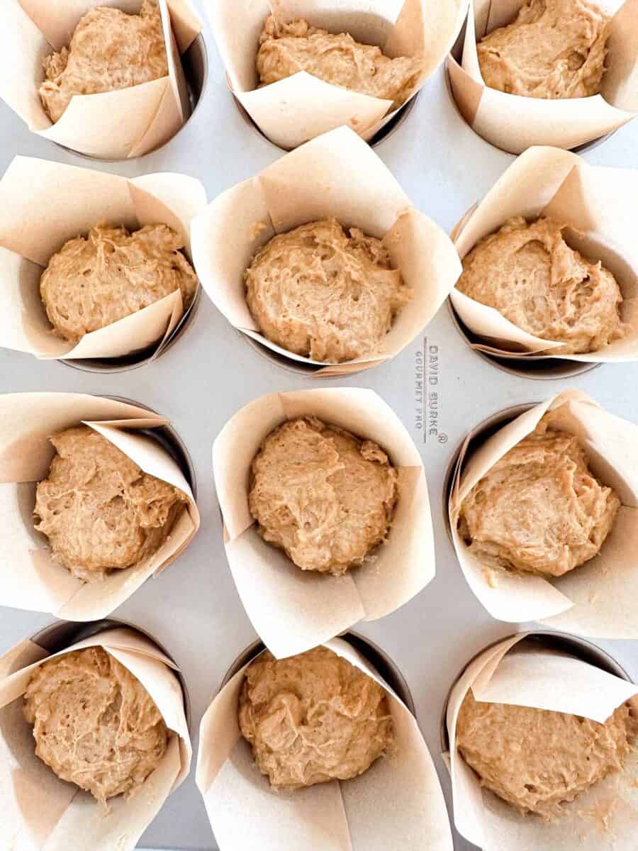 A muffin pan filled with sourdough pumpkin muffin batter.