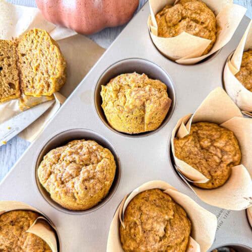 Pumpkin sourdough muffins in a muffin tin.