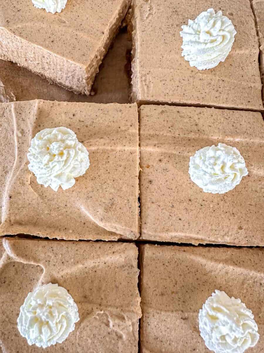 Square slices of pumpkin pie cheesecake bars.