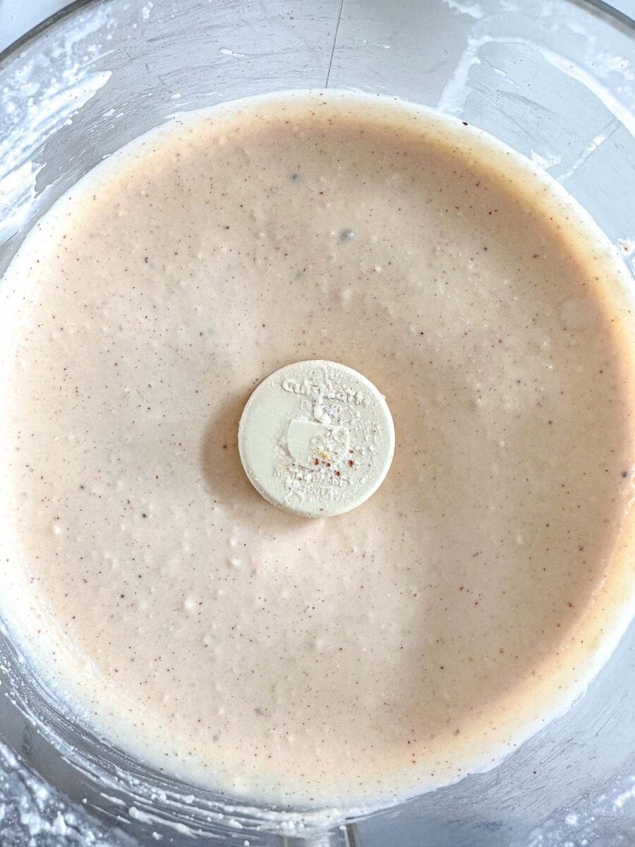 A food processor bowl filled with mac and cheese sauce.