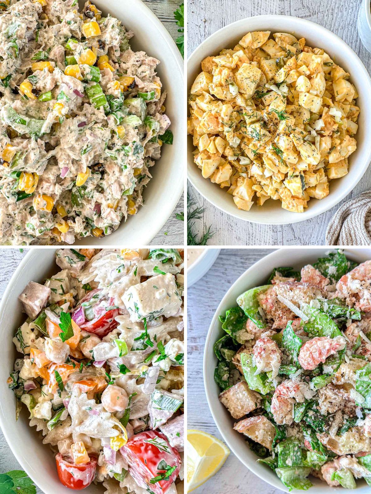 Four bowls of different creamy salads placed on a light surface: tuna salad with corn and herbs, egg salad with dill, chicken salad with tomatoes and parsley, and Caesar salad with croutons and parmesan.