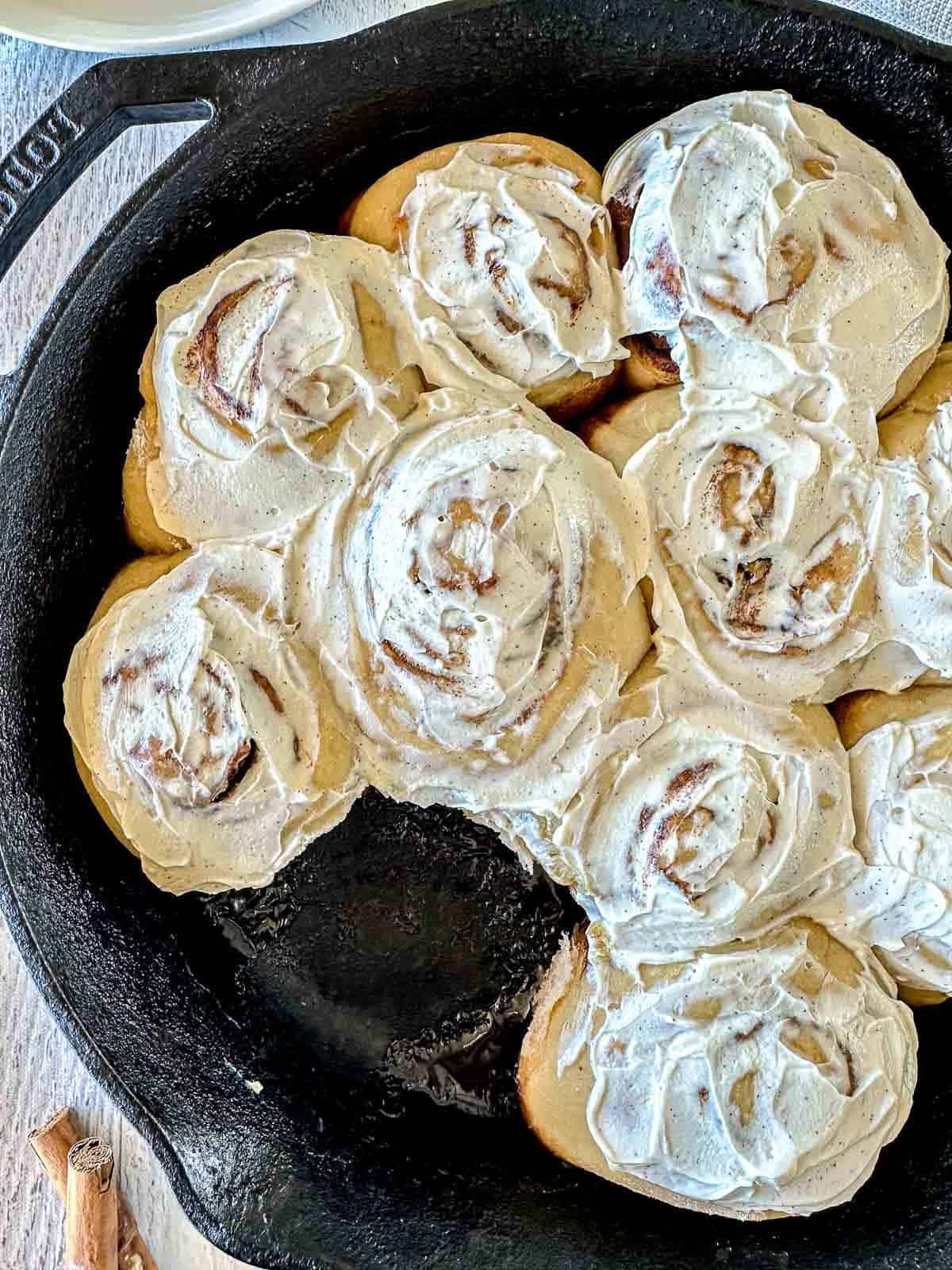Sourdough Cinnamon rolls with vanilla bean frosting in a cast iron skillet.
